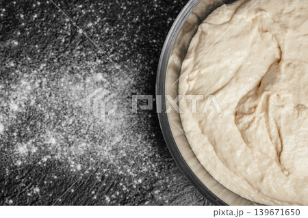 Fermented sourdough dough in metal bowl on dark rustic background with copy space for bakery advertising 139671650