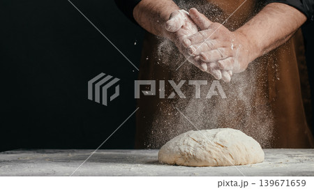 Professional baker dusting flour over fresh dough on dark background with copy space for artisan bakery concept Professional baker dusting flour over fresh dough on dark background with copy space for artisan bakery concept 139671659