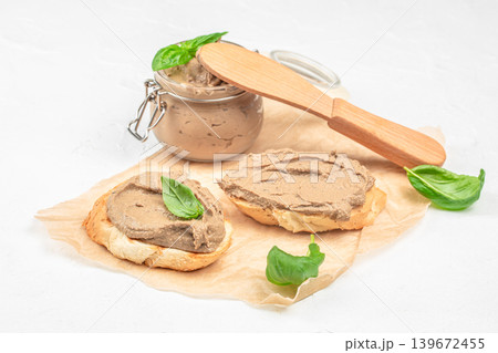 Liver pate spread on bread with jar and basil on light background with copy space 139672455