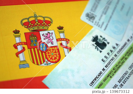 Citizenship or naturalization certificate document and card on flag of Spain Citizenship or naturalization certificate document and card on flag of Spain 139673312