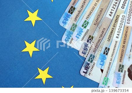 Permanent resident or residence permit cards lies on European Union flag. Paper specimen cards 139673354