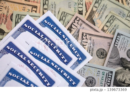 Social security number cards on many US dollar money bills Social security number cards on many US dollar money bills 139673369
