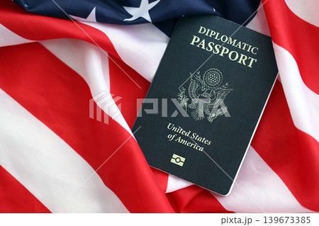 United States diplomatic passport book on US flag close up. Travel document on official banner 139673385
