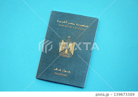 Egyptian passport book on light blue paper background close up. Travel document Egyptian passport book on light blue paper background close up. Travel document 139673389