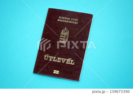 Hungarian passport book on light blue paper background close up. Travel document 139673390