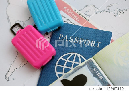 Passport and visa with boarding pass tickets and toy luggage bags on world map Passport and visa with boarding pass tickets and toy luggage bags on world map 139673394