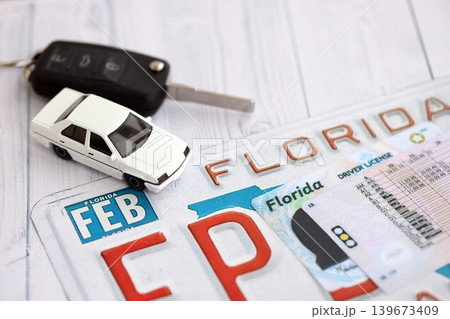 Remote control car keys on Florida license plate with driver license. Car driving in Florida Remote control car keys on Florida license plate with driver license. Car driving in Florida 139673409