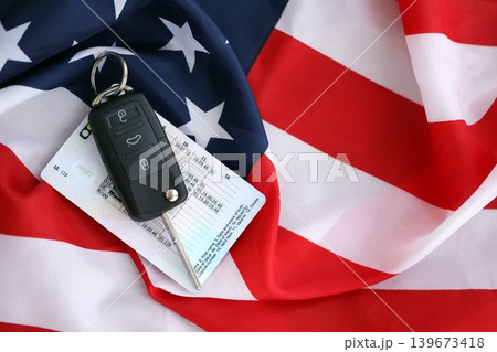 Ignition keys with remote control buttons and driver license card on United States flag Ignition keys with remote control buttons and driver license card on United States flag 139673418