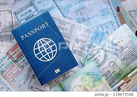 One fictional passport on big amount of passport pages full of colorful stamps after travel One fictional passport on big amount of passport pages full of colorful stamps after travel 139673586