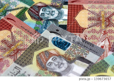 Omani rial paper banknotes pile on table. Oman OMR currency money bills in big amount Omani rial paper banknotes pile on table. Oman OMR currency money bills in big amount 139673657