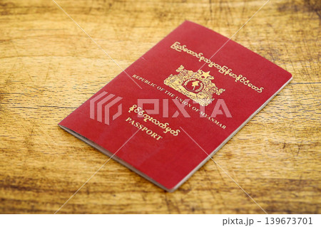 Myanmar passport on table close up. Official identification document book for citizens of Myanmar Myanmar passport on table close up. Official identification document book for citizens of Myanmar 139673701