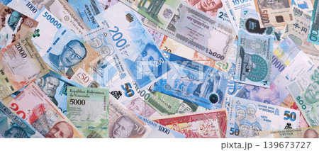 Different colorful banknotes from many various currencies of the world. Big stack of money bills Different colorful banknotes from many various currencies of the world. Big stack of money bills 139673727