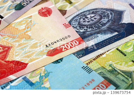 Uzbek som money bills pile on table. Uzbekistan banknotes of UZN currency close up Uzbek som money bills pile on table. Uzbekistan banknotes of UZN currency close up 139673754