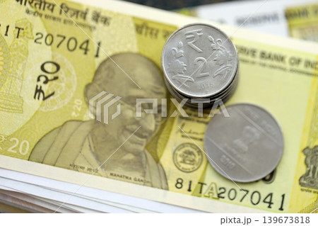 Indian rupee money bills and paisa coins pile on table. India coins on banknotes of INR currency 139673818