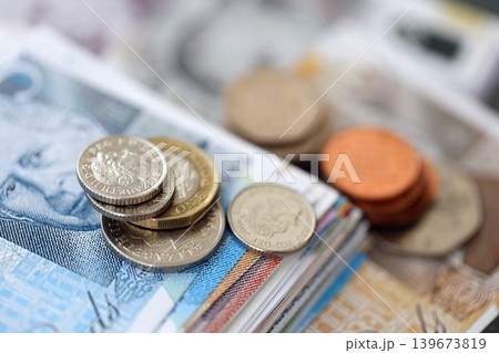 British pound money bills and penny coins pile. United Kingdom coins on banknotes of GBP currency 139673819