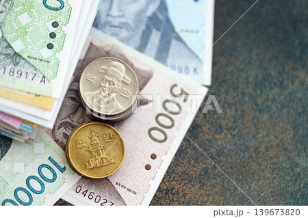 South Korean won money bills and jeon coins pile. South Korea coins on banknotes of KRW currency 139673820
