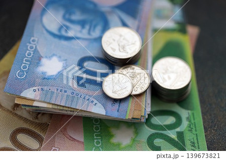 Canadian dollar money bills and cent coins pile on table. Canada coins on banknotes of CAD currency Canadian dollar money bills and cent coins pile on table. Canada coins on banknotes of CAD currency 139673821
