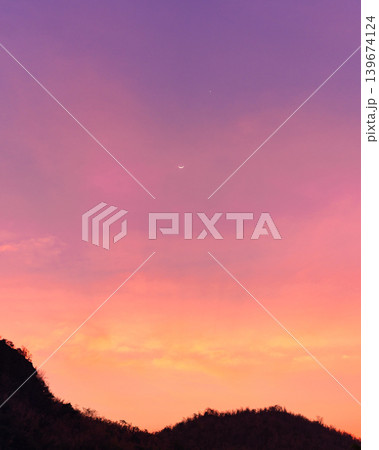 Colorful sky with crescent moon and star over mountain 139674124