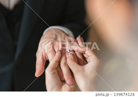 Romantic moment of a bridge and groom exchanging diamond rings during wedding ceremony Romantic moment of a bridge and groom exchanging diamond rings during wedding ceremony 139674128