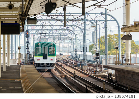 Electric railway train with metal structure and tracks arrival to station at Kyoto Electric railway train with metal structure and tracks arrival to station at Kyoto 139674181