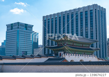 Seoul, South Korea - May. 14, 2026 : Historical Gyeongbokgung Gwanghwamun Gate with modern city buildings under a blue sky in Seoul, South Korea 139674227
