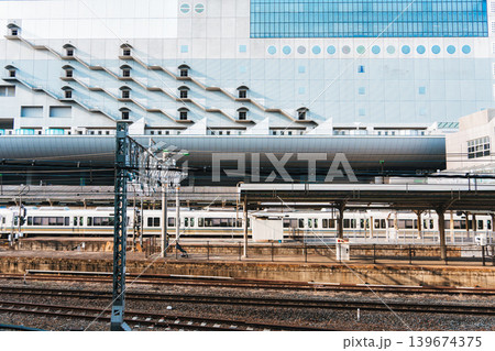 Modern railway station platform with commuter train and modern geometric building in the city 139674375
