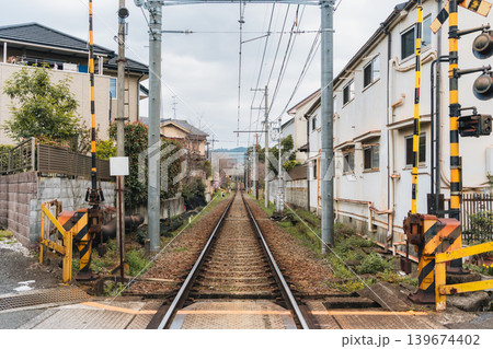 Railway track with wire cable among community during springtime in suburban 139674402