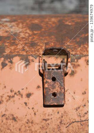 Close up of a rusty metal latch on an orange surface Close up of a rusty metal latch on an orange surface 139674979