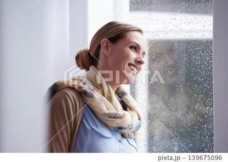 Thinking, rain and woman by window in home for nostalgia, wondering and remember in living room. Inspiration, daydreaming and person with thoughtful, contemplating and memory in house in winter Thinking, rain and woman by window in home for nostalgia, wondering and remember in living room. Inspiration, daydreaming and person with thoughtful, contemplating and memory in house in winter 139675096