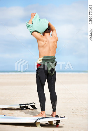 Surfing, man and getting ready with surfboard on beach with wetsuit, blue sky and dressing with mock up space. Rear view, person and athlete by ocean for training, surfer workout and extreme sports Surfing, man and getting ready with surfboard on beach with wetsuit, blue sky and dressing with mock up space. Rear view, person and athlete by ocean for training, surfer workout and extreme sports 139675165