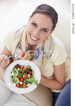 Top view of woman, eating salad and food for nutrition, vegetables and lunch with happiness in portrait. Diet, wellness and healthy vegan meal for cholesterol, detox and snack for dinner at home Top view of woman, eating salad and food for nutrition, vegetables and lunch with happiness in portrait. Diet, wellness and healthy vegan meal for cholesterol, detox and snack for dinner at home 139675245