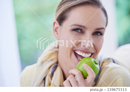 Portrait, eating or happy woman with apple for healthy or balanced diet with nutrition or vitamins. Face, weight loss or female person with fresh fruit, food or fibre for organic wellness in lounge Portrait, eating or happy woman with apple for healthy or balanced diet with nutrition or vitamins. Face, weight loss or female person with fresh fruit, food or fibre for organic wellness in lounge 139675313