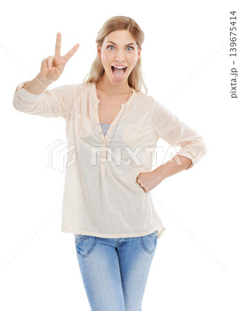 Portrait, tongue and peace sign with excited woman in studio isolated on white background for humor. Emoji, energy or comedy and confident young comic feeling silly or goofy with weird body language Portrait, tongue and peace sign with excited woman in studio isolated on white background for humor. Emoji, energy or comedy and confident young comic feeling silly or goofy with weird body language 139675414