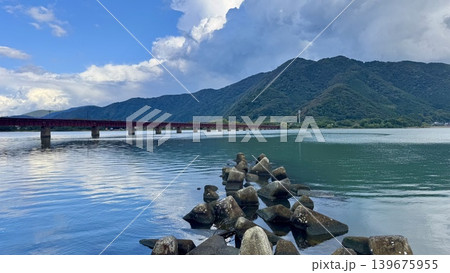 山間から伸びる鉄橋と雲が広がる川辺の風景 山間から伸びる鉄橋と雲が広がる川辺の風景 139675955