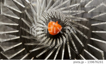 Top view on spiral geometric installation with metallic radial elements surrounding a red apple-shaped object in the center. Strong symmetry, depth and optical movement create a striking visual focus Top view on spiral geometric installation with metallic radial elements surrounding a red apple-shaped object in the center. Strong symmetry, depth and optical movement create a striking visual focus 139676281