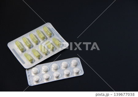 Pharmaceutical pills and capsules in blister pack on dark background Pharmaceutical pills and capsules in blister pack on dark background 139677038