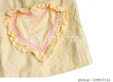 Yellow checkered fabric with pink heart-shaped ruffle pattern on white background Yellow checkered fabric with pink heart-shaped ruffle pattern on white background 139677212