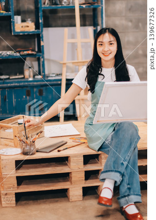 Female artist wears black hat posing near picture indoor the studio 139677326