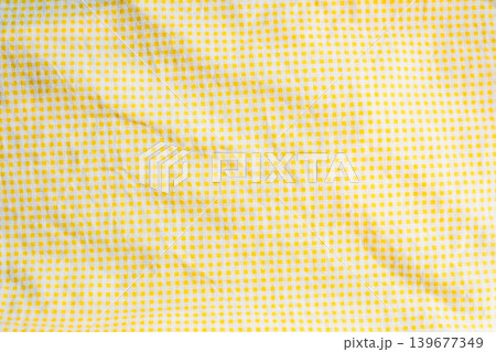 Yellow and white checkered textile fabric background with creases Yellow and white checkered textile fabric background with creases 139677349