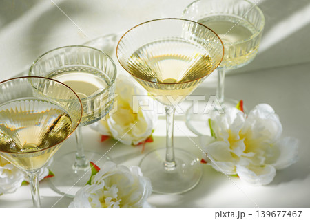 Champagne Glasses with White Peonies ib Sunlight Champagne Glasses with White Peonies ib Sunlight 139677467