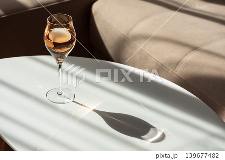 Rose Wine Glass with Shadows on White Table Rose Wine Glass with Shadows on White Table 139677482