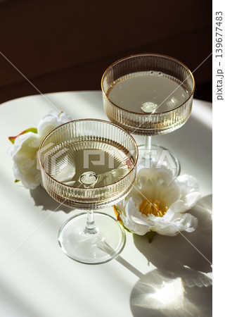Champagne Glasses with Flowers under Sunlight. Champagne Glasses with Flowers under Sunlight. 139677483