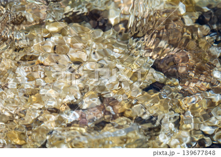 Rippling water over stones capturing nature's calming essence and fluid movement 139677848
