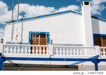 Charming mediterranean house with blue details and white walls under clear sky Charming mediterranean house with blue details and white walls under clear sky 139677909