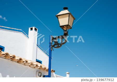 Mediterranean streetlight against clear blue sky in traditional white village setting Mediterranean streetlight against clear blue sky in traditional white village setting 139677912