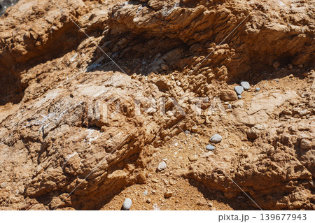 Close-up of weathered rocky surface with pebbles highlighting natural erosion patterns Close-up of weathered rocky surface with pebbles highlighting natural erosion patterns 139677943
