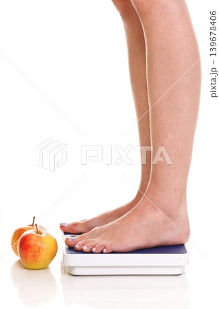 Woman feet and weight scale isolated on white background Woman feet and weight scale isolated on white background 139678406