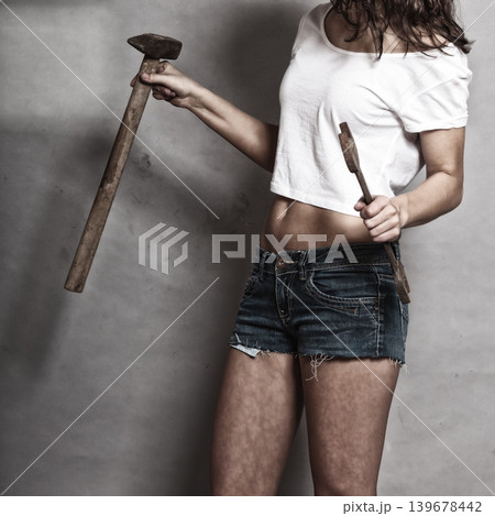 Sexy girl holding hammer and wrench spanner Sexy girl holding hammer and wrench spanner 139678442