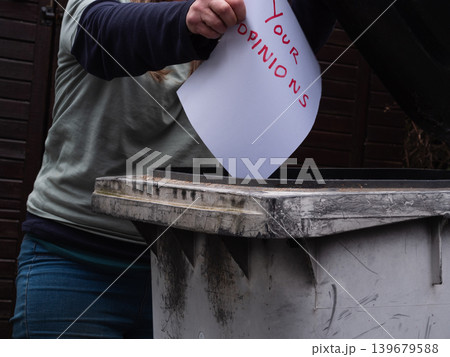 Woman putting opnions in the trash bin 139679588