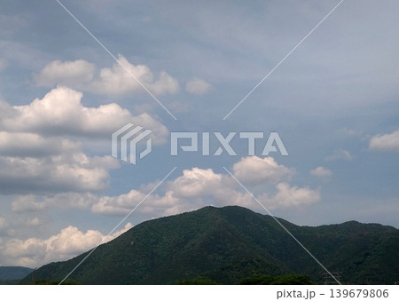 雲が浮かぶ空と山並みが広がる穏やかな自然風景 雲が浮かぶ空と山並みが広がる穏やかな自然風景 139679806